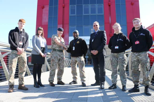 Major Goodwin, third left, with uniformed protective services staff, students and college principal Andrew Cropley, third right.