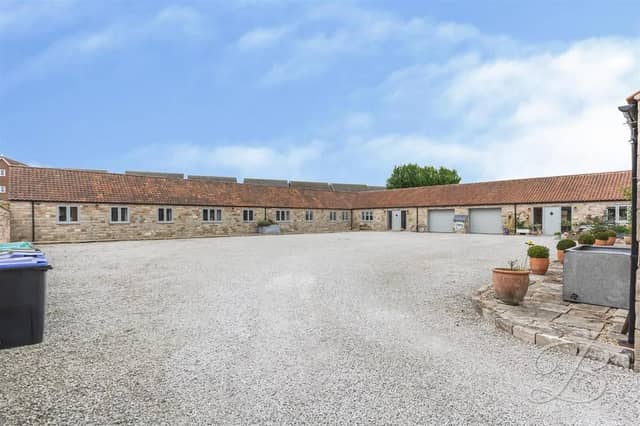 The striking and spacious property boasts a graveled driveway and a garage, providing excellent off-street parking.