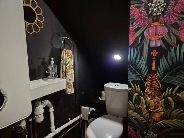 This space has a low level flush W/C, a wall-mounted wash basin, a wall-mounted Nest combi boiler and lvt flooring.