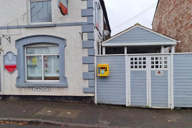The defibrillator is located outside the White Lion pub.