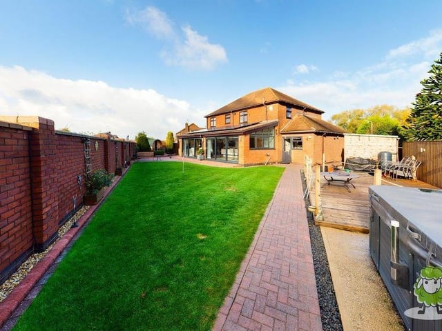 Moving outside now, and here is a view from the rear of the Riverside Way plot. A private and sizeable garden includes a lawn, pathway, decking area with hot tub and patio area with free-standing sauna.