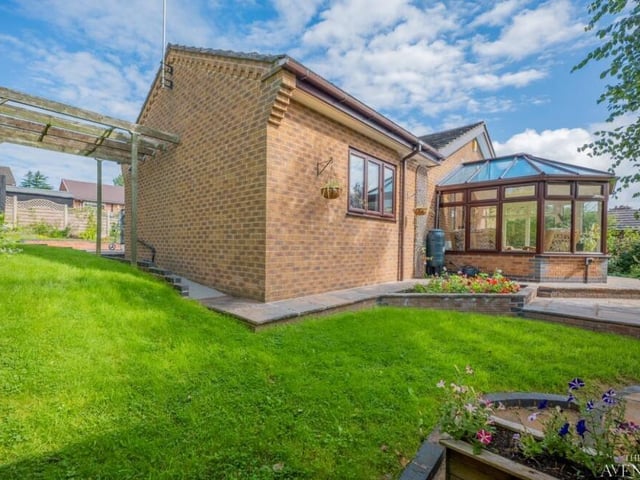 An unusual side shot, showing how the conservatory juts out from the bungalow on to one of two patio areas.