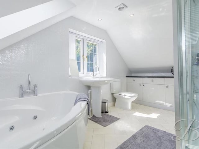Also on the first floor of the annexe is a landing and this bathroom, which has a fitted corner Jacuzzi bath, walk-in shower cubicle, low-flush WC, hand wash basin and fitted storage cupboard.