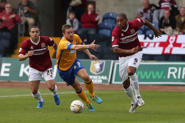 Clive Platt of Northampton Town moves forward with the ball past Jamie McGuire of Mansfield in 2013.