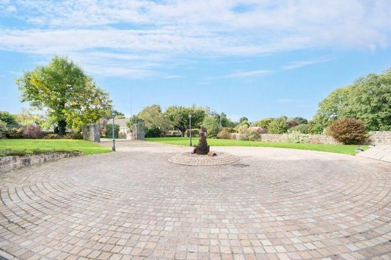 The gates lead on to a block-paved driveway, with turning circle, that provides lots of off-street parking space. Nearby is a detached double garage.
