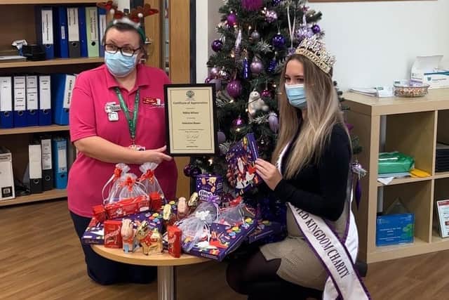 One of the nurses at King's Mill Hospital receives the chocolates and selection boxes and presents Nikita with a certificate of appreciation.
