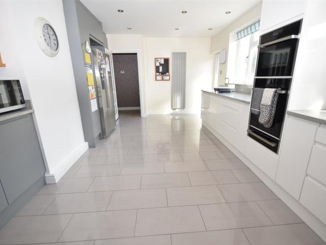 Style and sparkle emanate from the kitchen, where there is plenty of room for a dining table and chairs. Fixtures include an integral oven, combination microwave, warming tray, four-ring ceramic hob with extractor above and dishwasher. The room is finished with tiled flooring and two modern column-radiators.