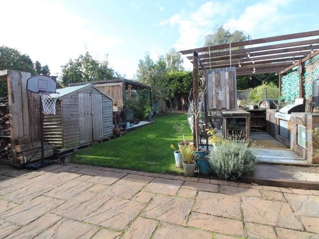 The busy back garden includes a wood store and a timber-built shed.