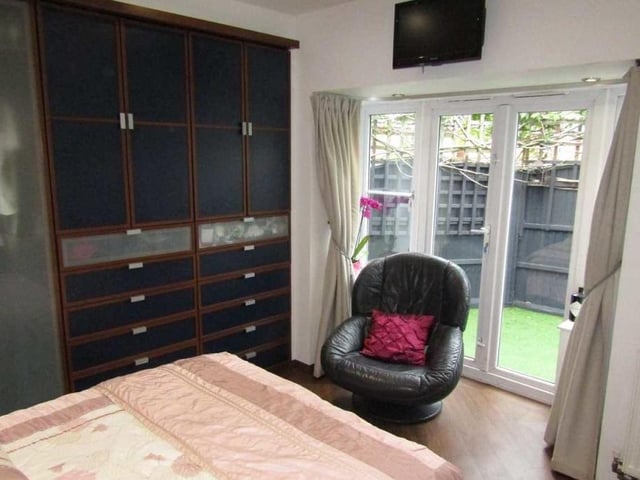 Here is the first. and largest, bedroom, which has a double-glazed French door facing the front of the bungalow. It also features large fitted wardrobes.