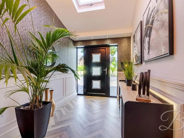 Upon entering, you're welcomed by an elegant entrance hallway with quality flooring and a warm, inviting feel.