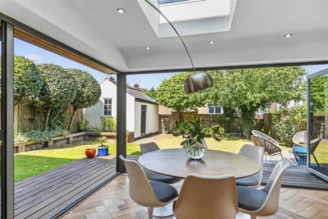 A superb open plan family living/dining kitchen with two large roof skylights and two sets of contemporary aluminium bi-folding doors leading out onto the rear garden.
