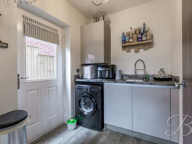 Close to the kitchen is this useful utility room, which has space and plumbing for a washing machine and tumble dryer. It is fitted with cabinets, worktops and an inset sink and drainer.