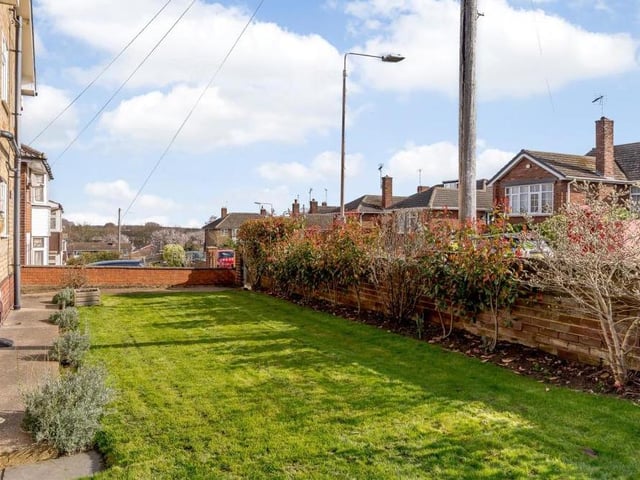 The gardens at the front and side of the house are laid to lawn. There are also borders with plants, while a pathway extends around the property.