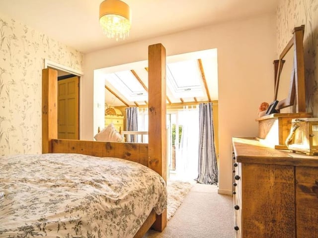 The main bedroom includes steps down to a dressing area, which has two Velux roof windows. Sliding doors also give access to the back garden and stunning views over fields.