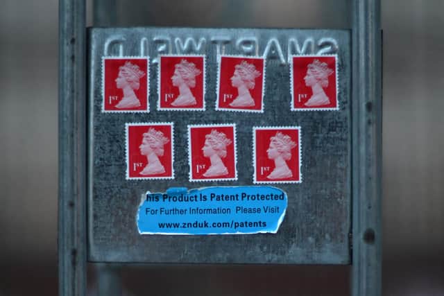 A tribute in the form of 1st class stamps bearing the image of Queen Elizabeth II is pictured stuck to railings outside of Buckingham Palace.