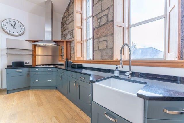 Three feature double glazed windows in the kitchen are set within natural stone and complemented by hardwood shutters made from original church pews.