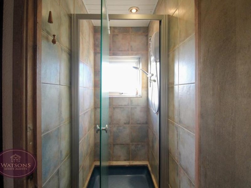 This shower room can also be found on the ground floor. A shower cubicle and electric shower comes with ceiling spotlights and an extractor fan.