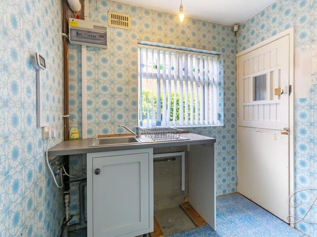 Next door to the kitchen is this small but handy utility room. It has space and plumbing for additional appliances, plus an inset sink and drainer.