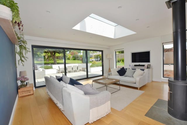 This second shot of the family room or garden room shows, in all their glory, the triple sliding bi-fold doors that offer views of the back garden and give access to a patio terrace. Along with the skylight, they make the room so bright and cheerful.