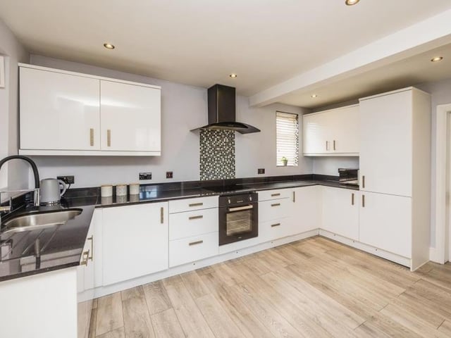 The kitchen is modern and open-plan, fitted with matching units for storage and regaled with essential appliances.