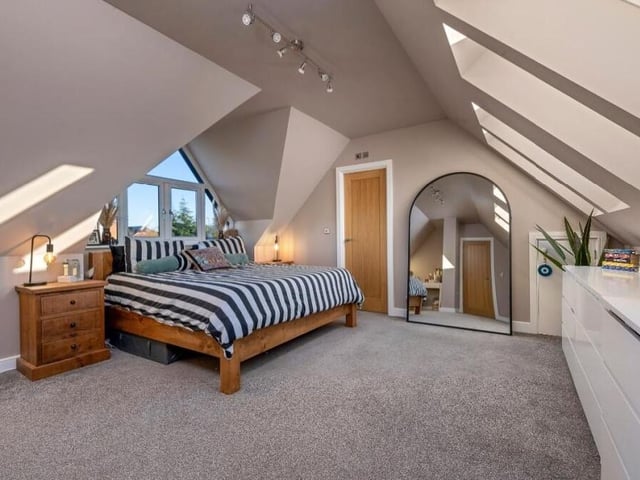 Three large double bedrooms can be found on the first floor, so let's start with the master, a dual-aspect room. It has access to a dressing room, which could be converted into an en suite shower room if necessary. It is currently fitted out with hanging rails and shelves.