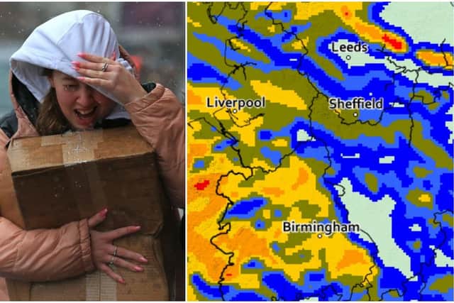 A woman tries to protect herself from high winds and rain in Sheffield (Photo by LINDSEY PARNABY/AFP via Getty Images)