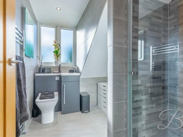 This is the second of the two excellent en suite shower rooms on the first floor. It comprises an enclosed shower, vanity hand wash basin, low-flush WC and full-height tiling.