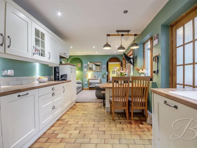 The kitchen leads onto a stylish dining area and a further inviting zone with plush carpeted flooring, central heating radiator and seamless access to the conservatory