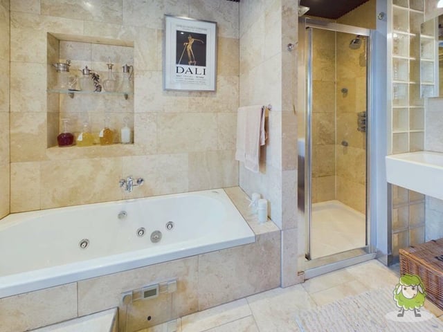 Here is the first of two en suite bathrooms on the first floor, serving the bedrooms. Stylish and modern, it features a bath, shower cubicle, low-flush WC and wash hand basin.