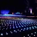 Sea Of Light - the dazzling Coldplay light show washes across the landscape in shimmering waves next to Belton House