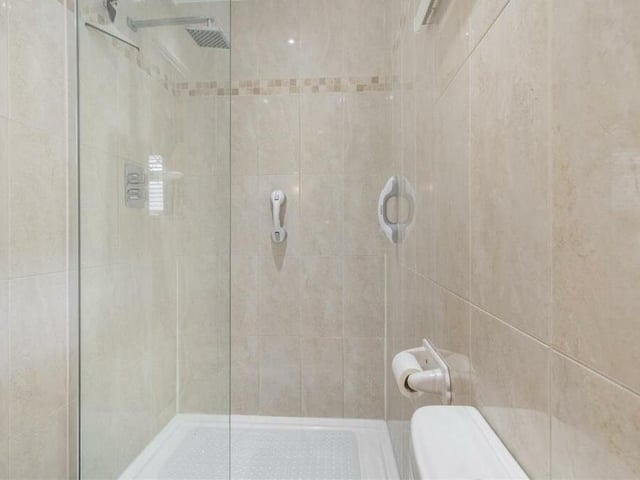 The en suite to the master bedroom also includes this walk-in shower, with wall-mounted rainfall shower. Nearby are a chrome, heated towel-rail, shaver point and four ceiling spotlights.
