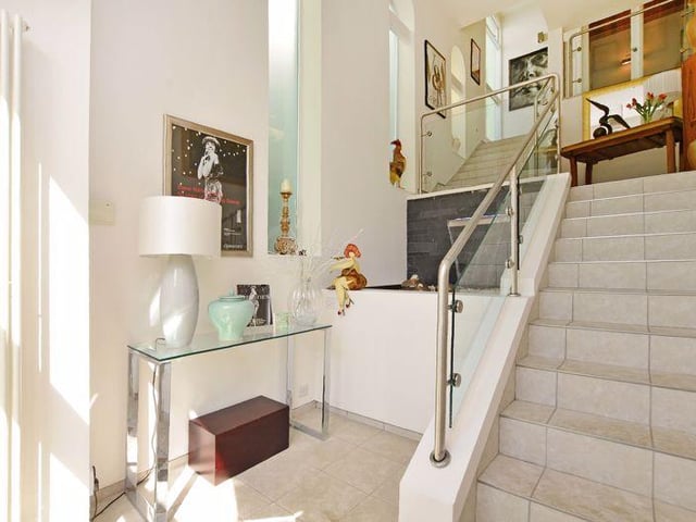 The stairs rise to a half landing with a cloakroom with a WC and wash basin. A small flight of stairs then leads to the upper floor.