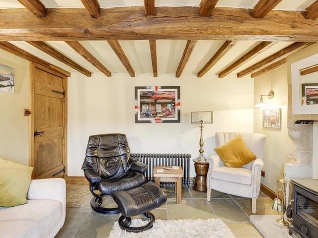 The living room also benefits from flagstone flooring, a TV point, a cast-iron column radiator, wall-light fixtures and a wood-framed sash window.