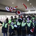 Mini police sing for shoppers.