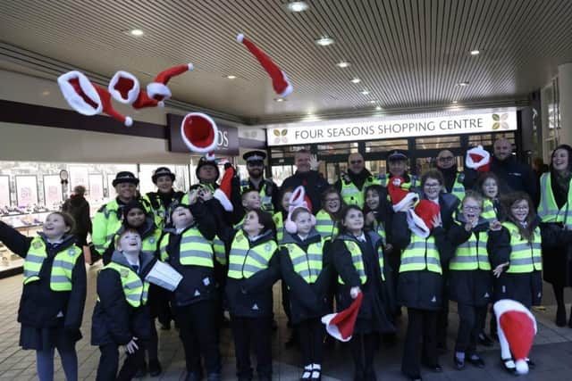 Mini police sing for shoppers.