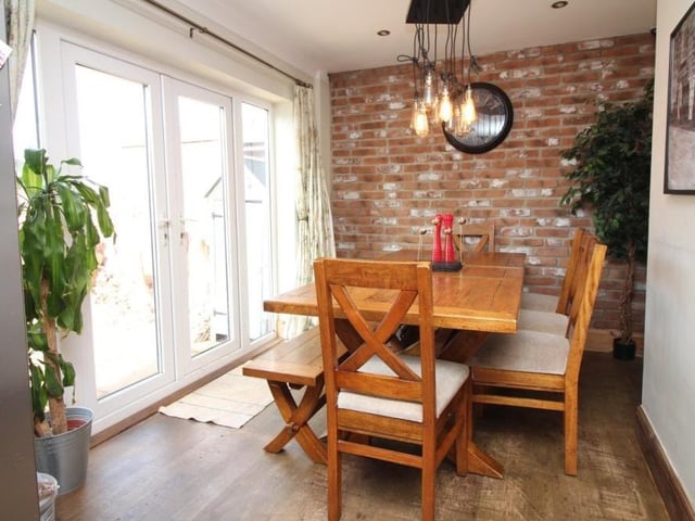 The dining area at the Swingate house is distinguished by a feature brick-style wall and French doors that lead to the back garden.