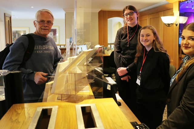 Kelly Nyland and Seven Mitchell check-in guest Steve Albery, watched by reception team leader Melissa Bell.
