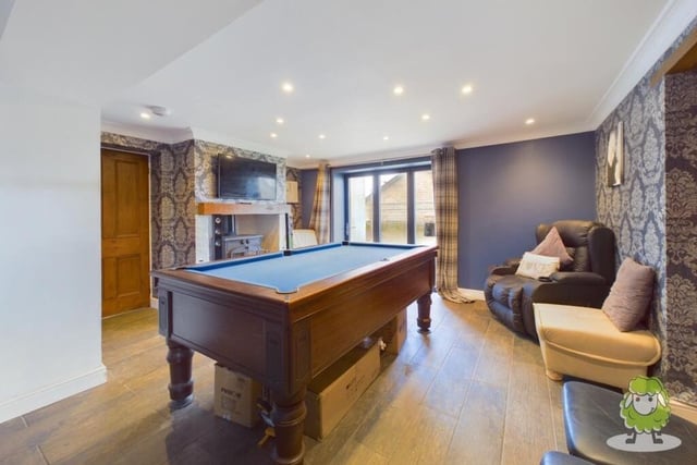 Attached to the breakfast kitchen is this living area, complete with feature fireplace and doors leading outside to the garden. As you can see, there is space for a pool table for a bit of family fun.