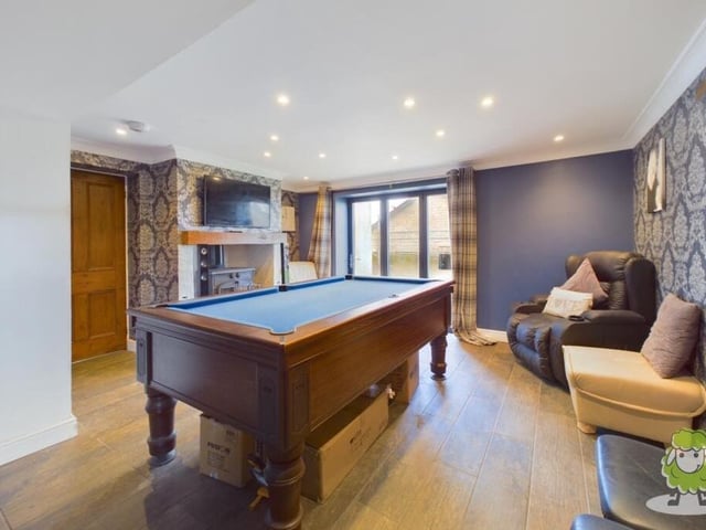 Attached to the breakfast kitchen is this living area, complete with feature fireplace and doors leading outside to the garden. As you can see, there is space for a pool table for a bit of family fun.