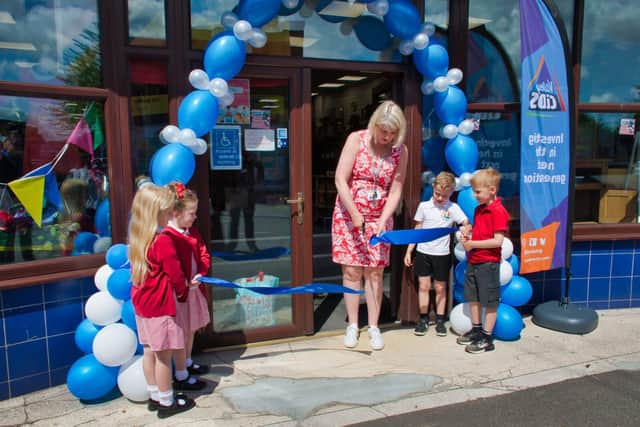 Pupils from The Brigg Infant School in South Normanton join headteacher Alison Spencer in cutting the ribbon to officially open the Lighthouse Charity Shop. Picture: Martin Wilson