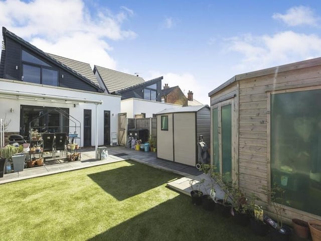 This view from the rear shows the main garden at the property, including an artificial lawn.