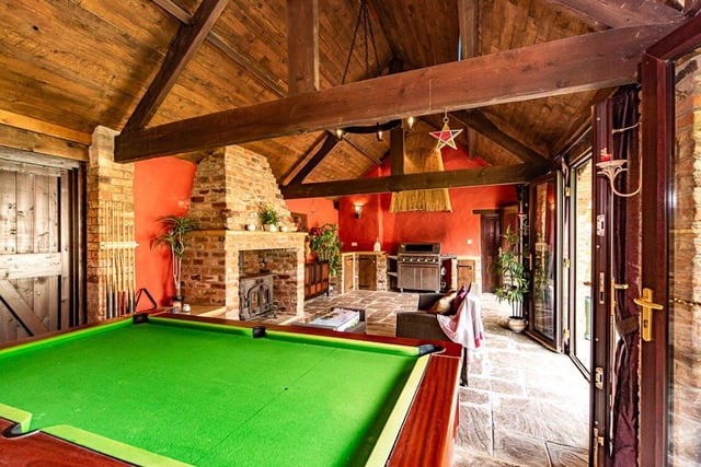 The room which looks out onto the garden has a fireplace, BBQ area and plenty of space for a pool table.