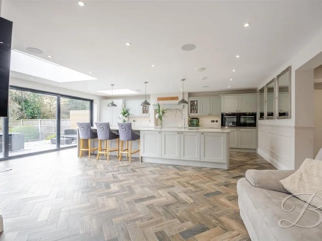 A true standout, the room features exquisite herringbone flooring that flows effortlessly from the hallway, enhanced by underfloor heating for year-round comfort. The sleek, modern cabinetry, complete with matching drawers, is beautifully complemented by generous marble countertops, creating a sophisticated yet practical kitchen space.