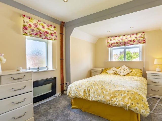 A bedroom with colour and character. It comes with a carpeted floor and downlights, while the windows face the front and side of the house.