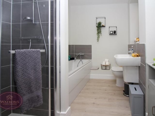 The family bathroom, which can be found on the top floor of the house, consists of a four-piece suite in white. There is a bath, shower cubicle with mains-fed shower, WC and wall-mounted sink, plus a chrome, heated towel-rail, extractor fan and ceiling spotlights.