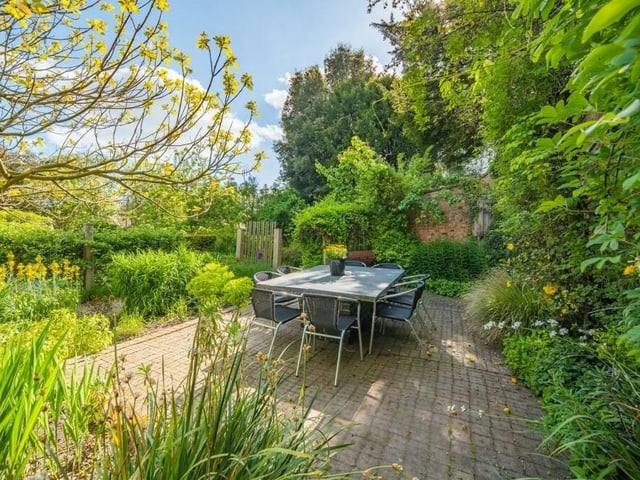 A pleasant patio with seating, nestling among the greenery.