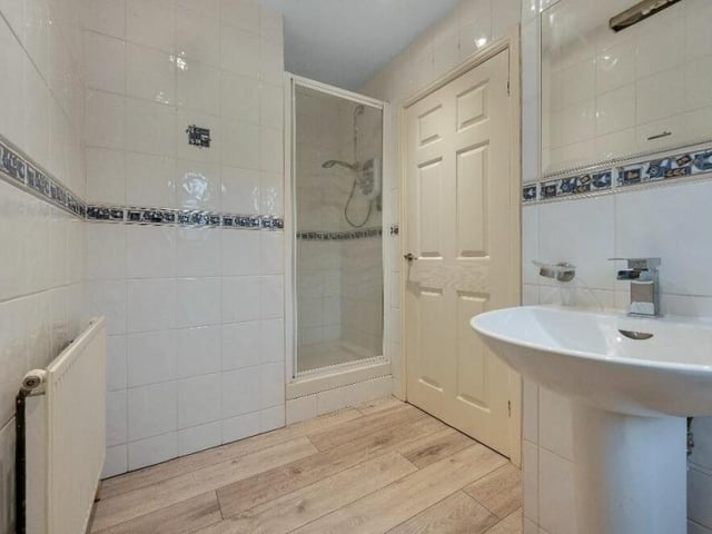 The second en suite also features a shower enclosure with wall-mounted, internally plumbed shower, plus a chrome, heated towel-rail and ceiling spotlights.