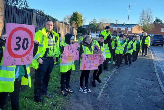 Youngsters with their signs at the side of the road.