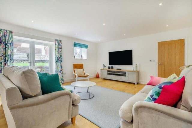 The lounge benefits from has underfloor heating with a thermostat control pad. There is an engineered oak floor, 12 ceiling spotlights and two narrow slit-windows facing the front of the property, as well as windows to the side and back.