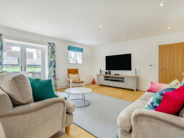 The lounge benefits from has underfloor heating with a thermostat control pad. There is an engineered oak floor, 12 ceiling spotlights and two narrow slit-windows facing the front of the property, as well as windows to the side and back.
